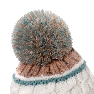 Close-up of a multi-color plush pom-pom on top of a thick cable knit winter hat
