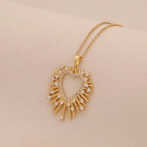 Detail of gold heart pendant with radiating rays and micro-set cubic zirconia stones