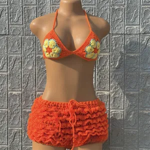 Detail of crochet bikini with orange ruffles and sunflower patterns on top