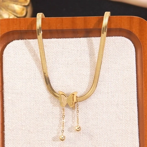 Golden butterfly pendant necklace with snake chain and tassel on elegant display