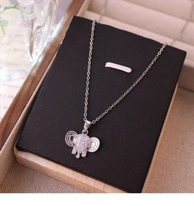 Detailed close-up of a silver elephant pendant with clear crystals and red stone eyes