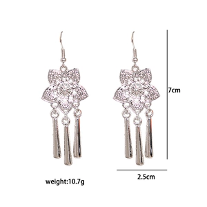 Detail view of ethnic silver earrings with hollow flowers and long hanging tassels