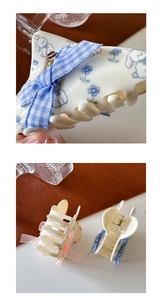 Detailed close-up showing acetate shark hair clips with blue floral print and pink ribbon bow