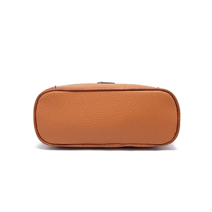 Detail view showing brown lychee textured leather and stitching on cross-body bag bottom