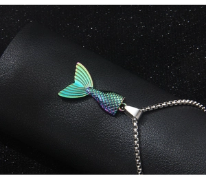 Macro view of rainbow mermaid tail pendant with detailed fish scale texture on silver chain