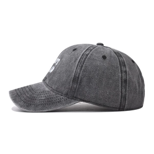 Detailed side view of charcoal grey washed cotton baseball cap with white embroidery
