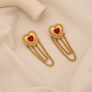 Elegant gold heart earrings with red gemstones and delicate tassel fringes on fabric