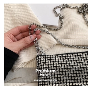 Detail shot of the silver metal chain and hook on the sparkling rhinestone evening clutch bag