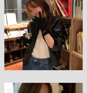 Close-up of black gloves with red bow detail worn by a model holding a vintage silver camera