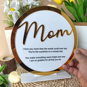 Macro shot of circular acrylic Mother's Day plaque with gold Mom text and heartfelt poem