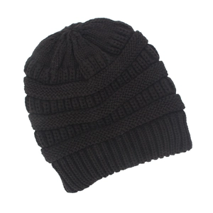 Close-up of black knitted beanie showing coarse knit texture and ribbed edge detail