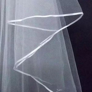 Minimalist double-layer bridal veil with satin ribbon edge detail on a dark background