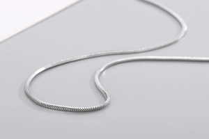 Macro shot of polished silver snake chain showing the detailed cylindrical link texture