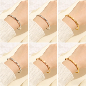 Dettaglio dei bracciali in acciaio inossidabile stile bambù in finitura argento e oro