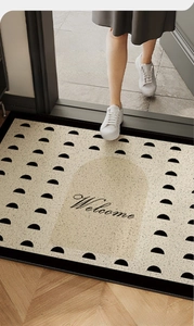 Nahaufnahme der cremefarbenen Welcome-Fußmatte mit schwarzem geometrischem Muster