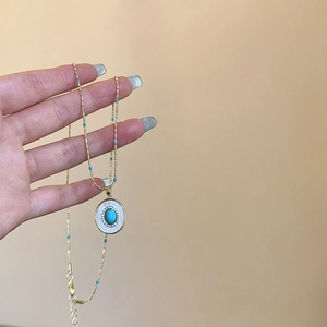 Collier doré avec pendentif ovale en turquoise, zircons et fines perles bleues sur chaîne