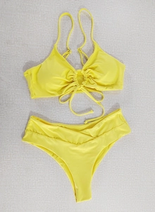 Detail of yellow halter bikini top with ruched center and V-cut high waist bottoms
