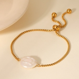 Detail of adjustable gold box chain bracelet with a lustrous baroque freshwater pearl