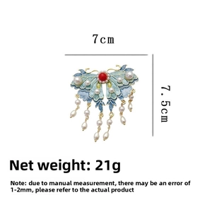 Détail d'une pince à cheveux papillon en émail bleu avec glands de perles, taille 7cm x 7,5cm
