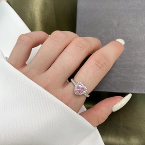 Macro shot of S925 sterling silver ring featuring a pink heart zircon on female hand