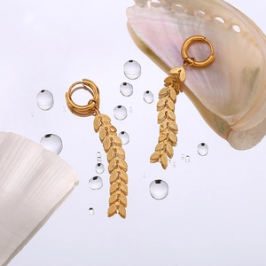 Minimalist 18K gold-plated stainless steel leaf drop earrings on water drop background