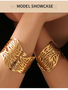 Detailed close-up of model wearing two irregular hollow leaf open cuff bracelets in gold