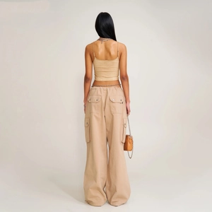 Rear view of khaki cargo parachute pants with drawstring detail and cropped camisole top