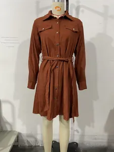 Detail of brown corduroy shirt dress featuring chest pockets and a matching waist belt