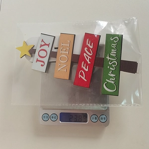 Detailed view of lightweight Christmas wooden tree sign weighing 23.8g on a digital scale