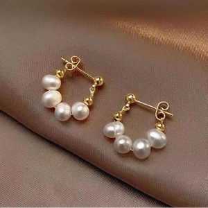 Baroque pearl beaded earrings in vintage French style on brown silk background