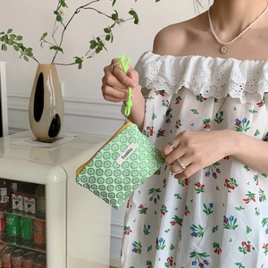 Close-up of green and white honeycomb jacquard fabric pouch with yellow zipper detail