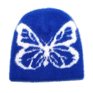 Detailed view of blue plush beanie with white butterfly jacquard pattern