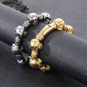 Detail of silver and gold punk skull bracelets with vintage engraved charms and clasp