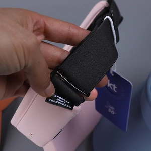 Detail of adjustable strap and UPF 50 tag on breathable light pink sports sun visor