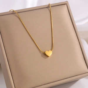 Elegant gold titanium heart pendant necklace displayed on a luxury champagne jewelry box