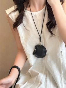 Detail of minimalist black faux leather magnetic glasses holder necklace with silver buckle