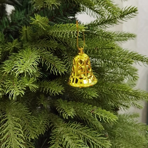 Nahaufnahme goldener hohler Weihnachtsklocken an festlichen Tannenzweigen