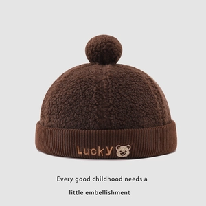 Close-up of the Lucky embroidery and cute bear patch on warm brown sherpa beanie
