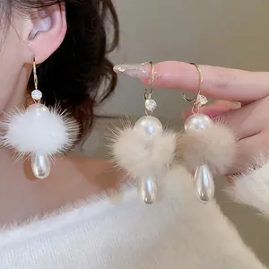 Elegant C-shaped earrings with plush fur balls and drop pearls for winter styling