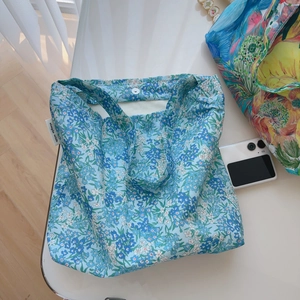 Chic floral cotton shoulder bag in blue featuring simple wish tag and secure snap button