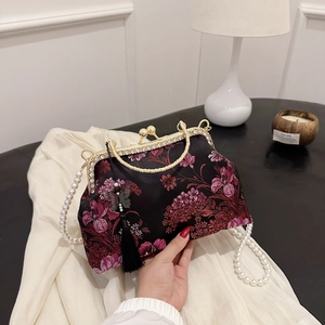 Floral embroidery handbag with gold rhinestone frame and pearl chain strap on white cloth