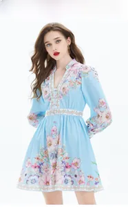 Détail de la robe bleu clair à manches lanternes avec imprimés floraux et col en V