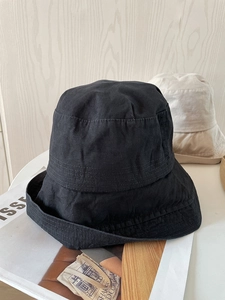 Detail of black cotton bucket hat showing decorative brim stitching and canvas texture