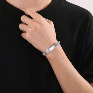 Detail shot of a silver polished rectangular bar on a link chain bracelet for men