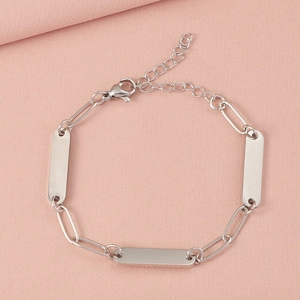 Detail of silver stainless steel paperclip chain bracelet with engravable blank plates