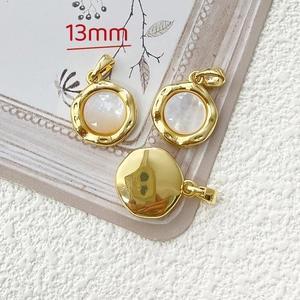 Macro detail of 13mm gold plated round pendants with iridescent white shell inlay