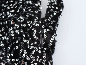Detail of silver sequins on black velvet fabric with a hidden zipper closure