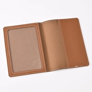 Detailed view of brown PU leather passport holder interior with clear ID window and white stitching