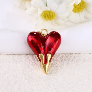 Detailed macro view of a red enamel heart pendant with 18k gold-plated metal base