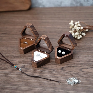 Macro shot of three geometric wooden jewelry boxes with clear lids and velvet cushions